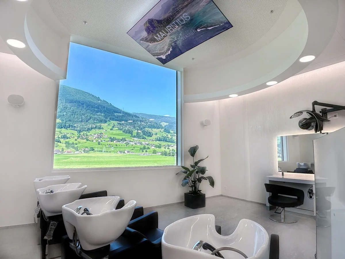 Heller Salon mit grossem Fenster und Bergpanorama